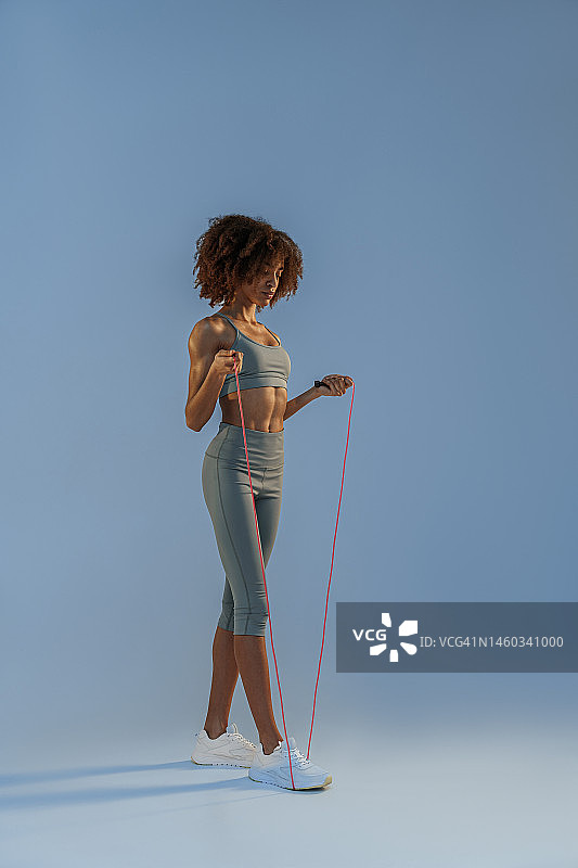 女子训练与跳绳工作室背景。力量和动力。最佳有氧运动图片素材