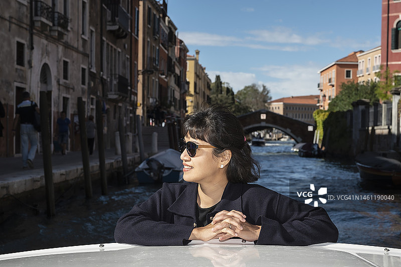 在威尼斯，一名女子正在享受乘船出租车之旅图片素材