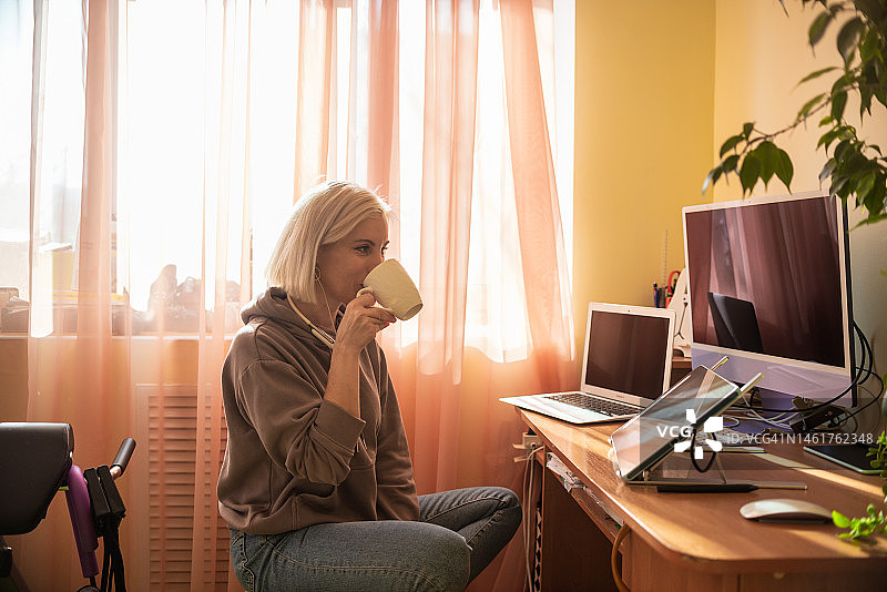 一位年轻的自由职业者，在家里工作后，在电脑前听音乐。图片素材