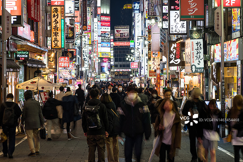 运动模糊拥挤的日本人，亚洲旅行者走在歌舞伎町街红灯区，东京新宿市。亚洲旅游旅游或日本娱乐夜生活派对概念图片素材
