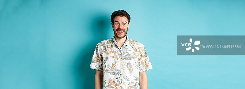 帅气的快乐男子在夏威夷衬衫看起来很有趣图片素材