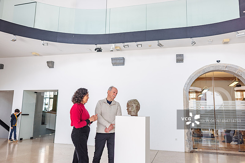 博物馆的高级游客在博物馆大厅欣赏雕像图片素材