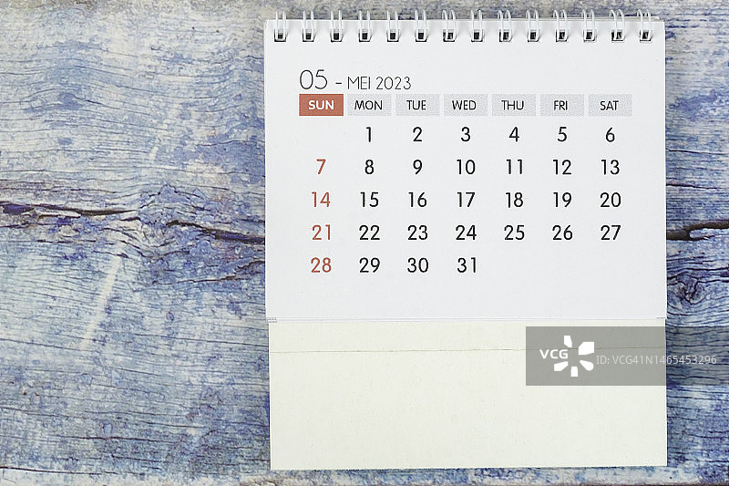 日历台2023:五月是组织者计划和最后期限的月份，蓝色木制背景。图片素材