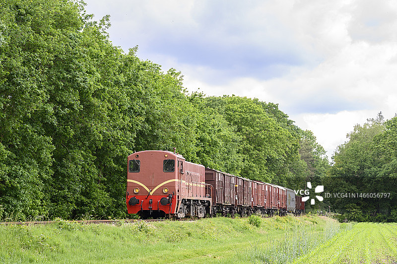 老旧的柴油机车列车与农村的货运铁路车厢图片素材