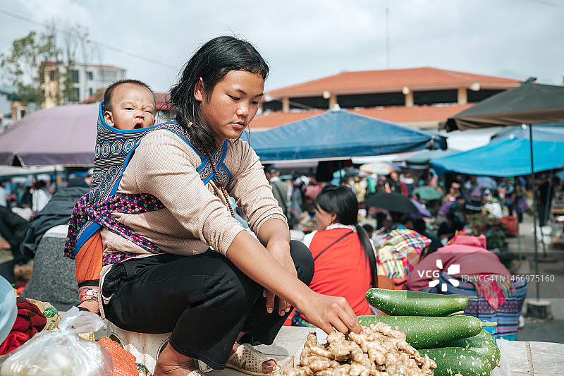 在萨帕地区的市场上，年轻的土著妇女背着婴儿图片素材