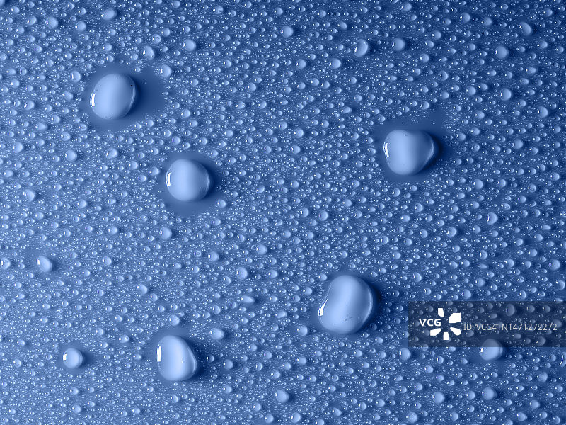 蓝色背景上的小水滴和水花。图片素材