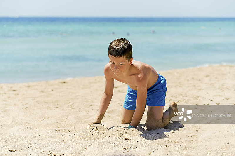 小男孩在海滩上玩耍。图片素材