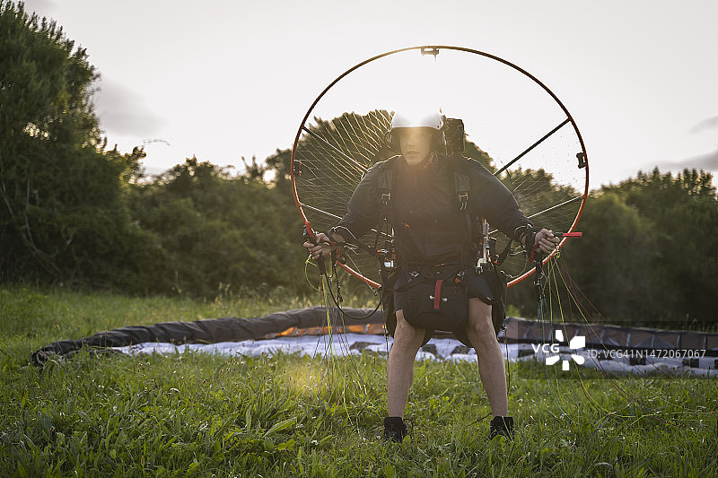 黄昏的滑翔伞冒险:教练准备独自飞行在风景如画的阿斯图里亚海岸线图片素材