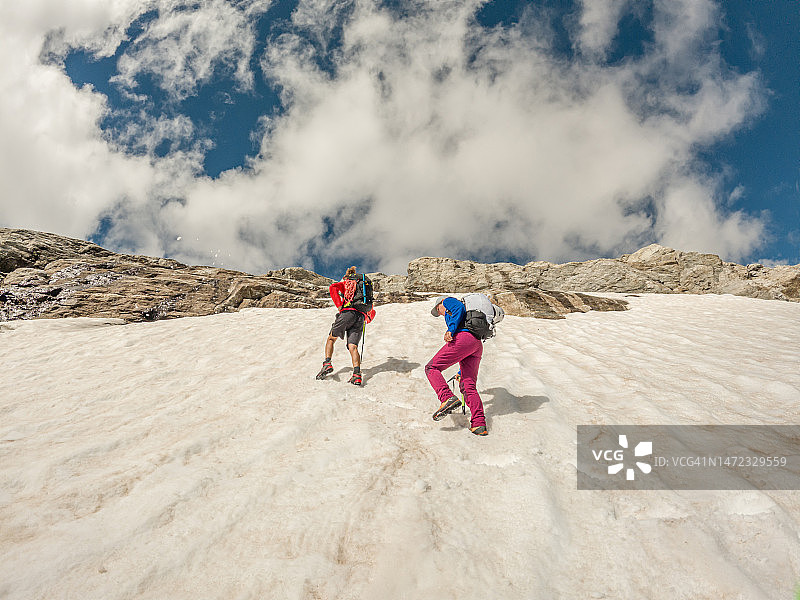 一对情侣在阿尔卑斯山的冰面上爬山图片素材