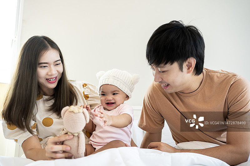 一个亚洲家庭的肖像，卧室里有一个刚出生的孩子。图片素材