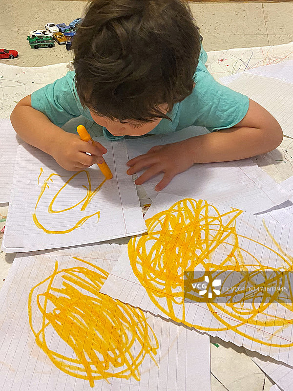 幼儿用彩色铅笔在纸上画画图片素材