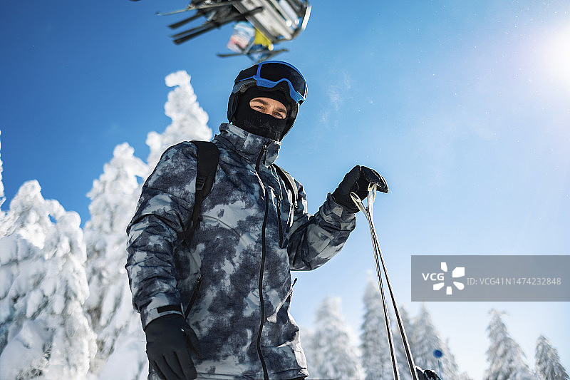 一个男人在雪地里拿着滑雪板的肖像图片素材
