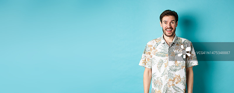 帅气的快乐男子在夏威夷衬衫看起来很有趣图片素材