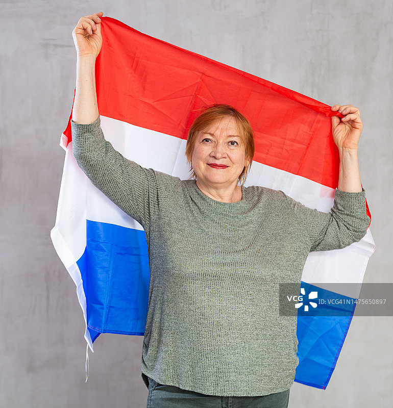 微笑的老年妇女挥舞着荷兰国旗图片素材