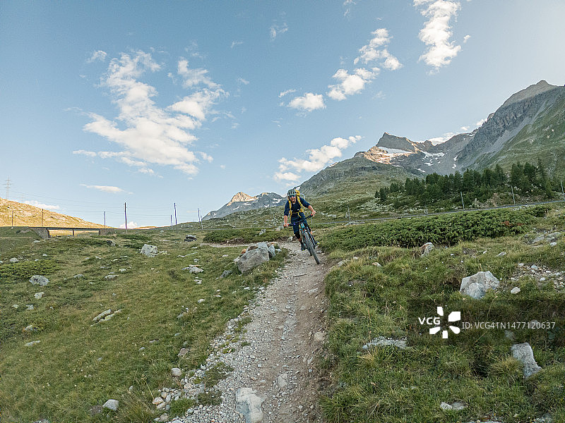 山地车手从阿尔卑斯山脉的小道上下来图片素材