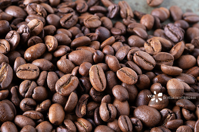 绿色表面上烘焙咖啡豆的特写图片素材