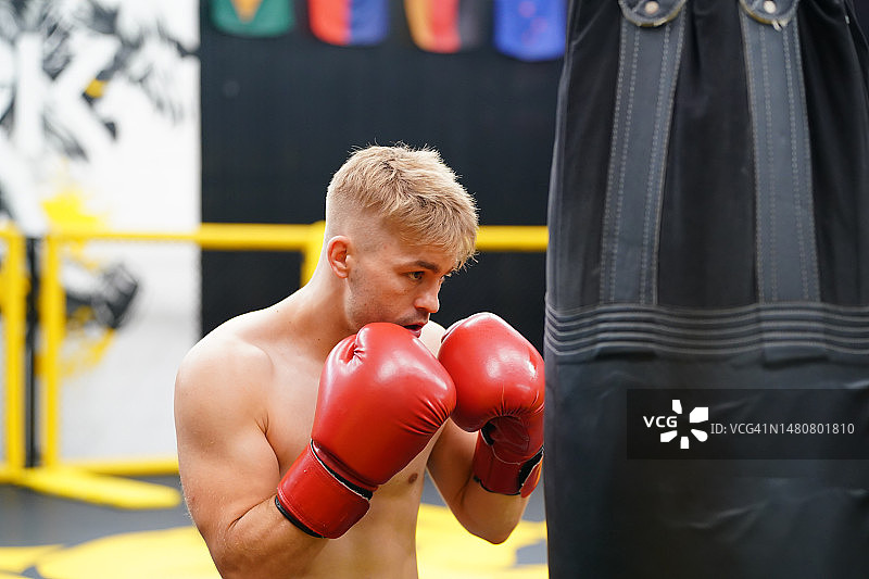 泰拳，泰国的武术，拳师练习用沙袋出拳来锻炼有力的出拳和肌肉。图片素材