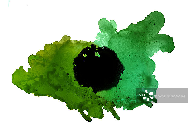 一滴绿色和黑色的油漆在白色的背景上滑动。图片素材
