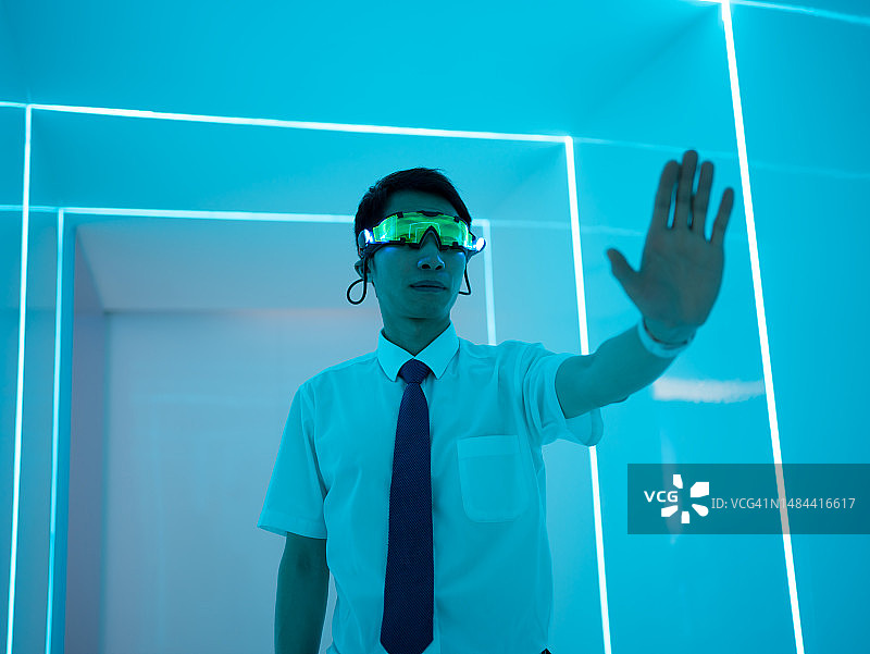 沉浸式:男人戴上VR眼镜，体验逼真的虚拟现实图片素材