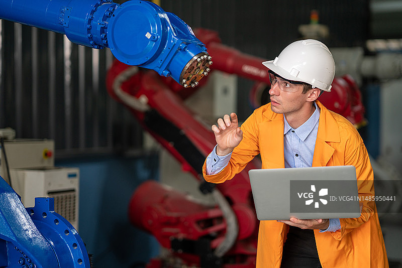 机器人机械工程师在机器人制造工厂测试控制器、传感器、操作系统、机械设计图片素材