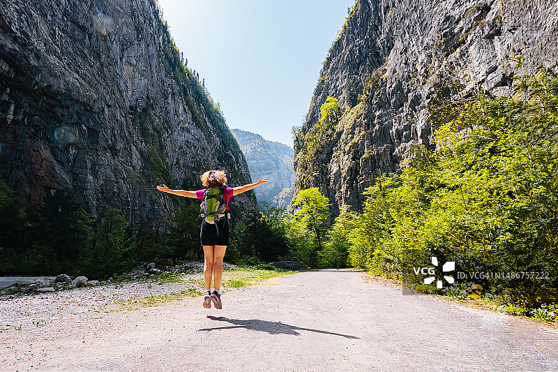 一位女徒步旅行者在峡谷中凝视着风景如画的景色。尤普沙尔基峡谷，尤普沙尔基峡谷，阿布哈兹图片素材