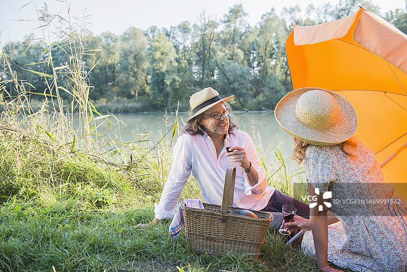 德国巴伐利亚州，一对情侣在湖边野餐、喝酒图片素材