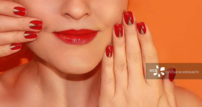 一个女人的红指甲和红口红。图片素材
