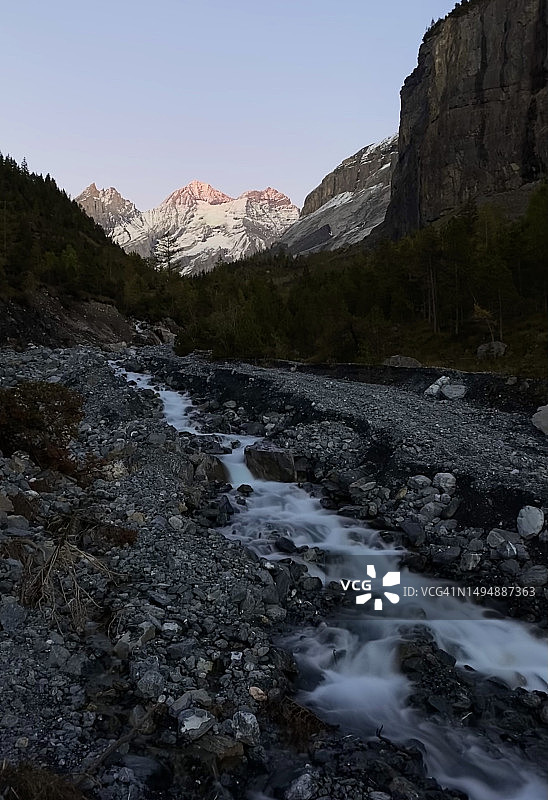 风景秀丽的河流在山脉对晴朗的天空，康得斯泰格，瑞士图片素材