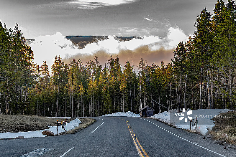 在美国西部，北美黄石生态系统，沿着通往钓鱼桥的高速公路，清晨的低云笼罩着森林图片素材