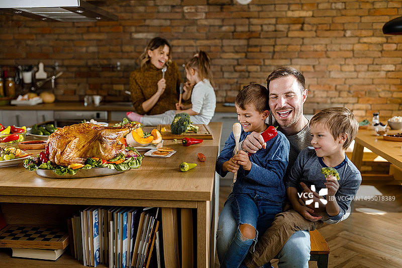 快乐的父亲和他的小男孩在厨房过感恩节。图片素材
