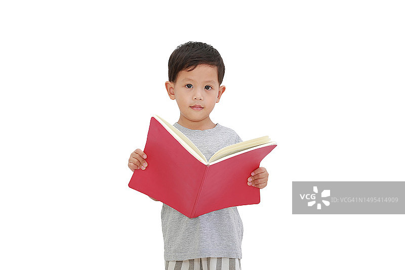 亚洲小男孩穿着便装，拿着打开的书，孤立在白色的背景上，看着相机。教育的概念图片素材