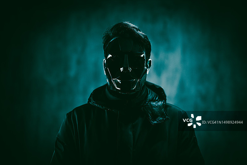 霓虹灯下戴着黑色面具的恐怖男子图片素材