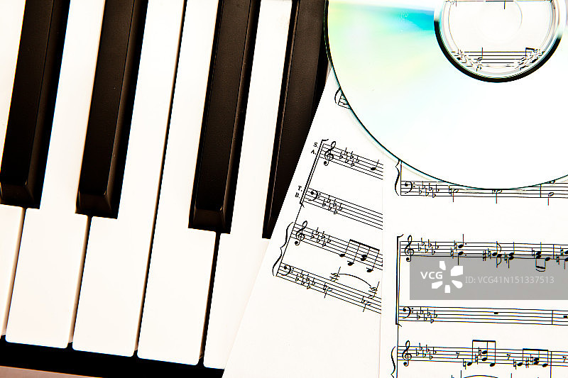 光盘和乐谱放在钢琴上图片素材