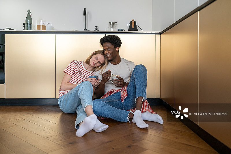 幸福的多元夫妻坐在厨房地板上在家里亲密无间图片素材