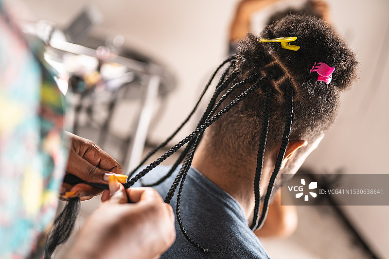 理发师正在给一个非洲裔男子编辫子图片素材