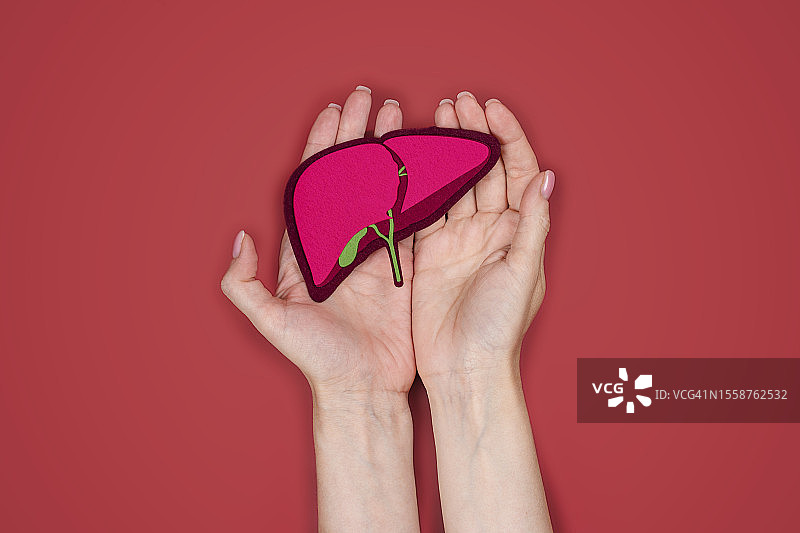 裁剪的手拿心形对粉红色的背景图片素材