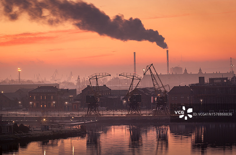 夕阳下，波兰什切青河边的工厂剪影映衬着天空图片素材