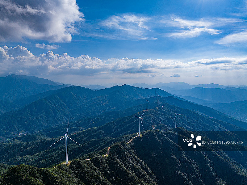 蓝天白云山上的风力发电设备航拍图图片素材
