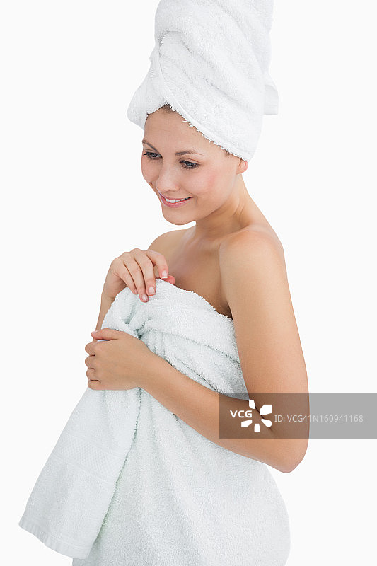 快乐的年轻女子裹在毛巾里图片素材