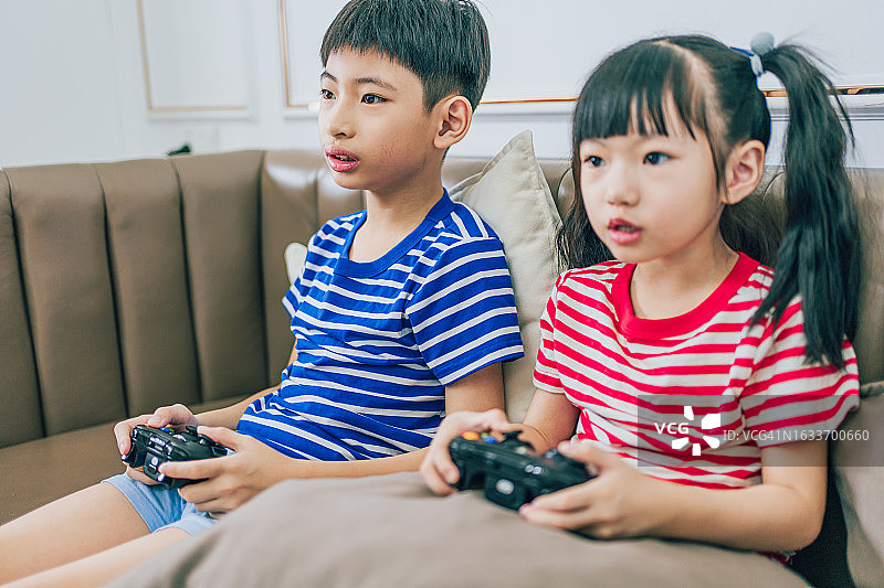 哥哥和妹妹在家里玩电子游戏图片素材