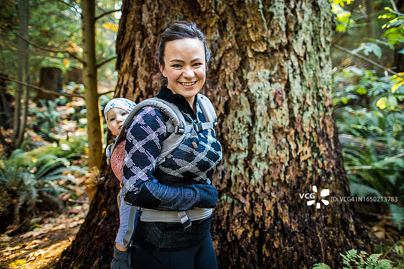 健康健美的妈妈背着婴儿背带，徒步旅行图片素材