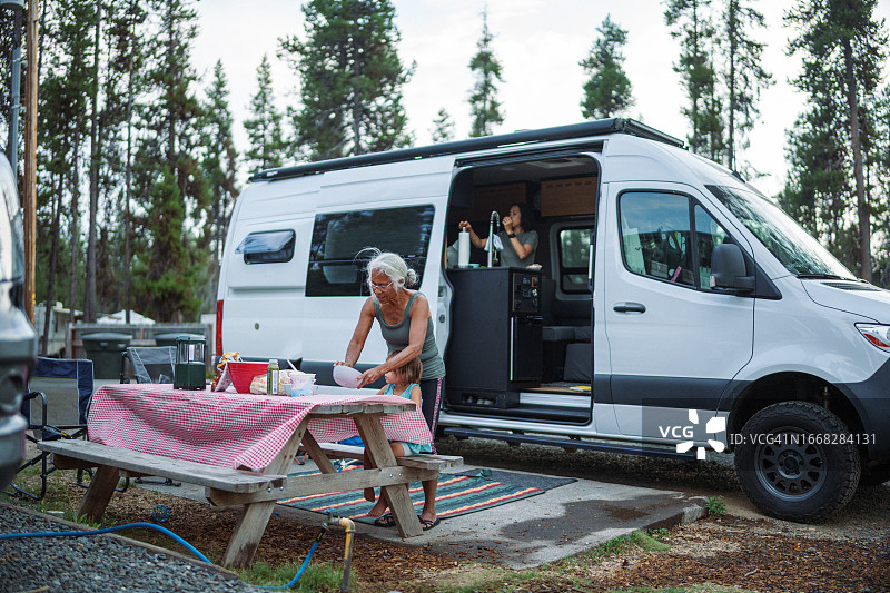 一位老年妇女在露营地的露营车外准备午餐图片素材