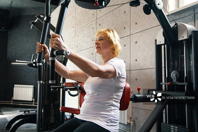 成熟女性在健身机上锻炼-力量训练成熟女性在健身机上锻炼-力量训练图片素材