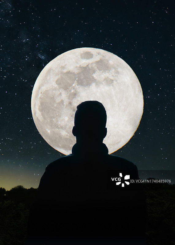 美国加州，一个年轻人的后视图，在满月和银河的映衬下图片素材