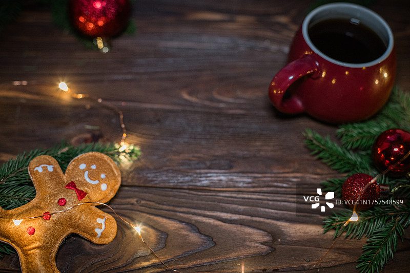 圣诞节的背景。一杯咖啡和姜饼人，姜饼饼干木制背景与圣诞灯图片素材