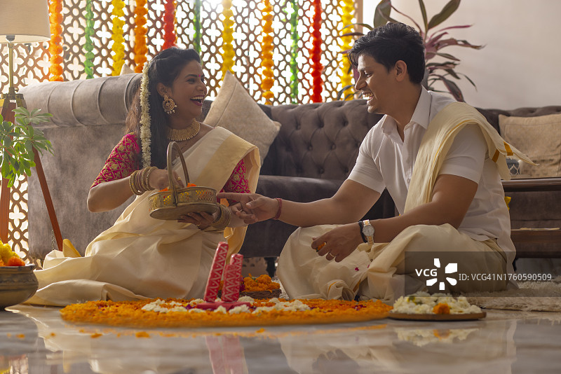 南印度夫妇用花环装饰房子来庆祝奥南图片素材