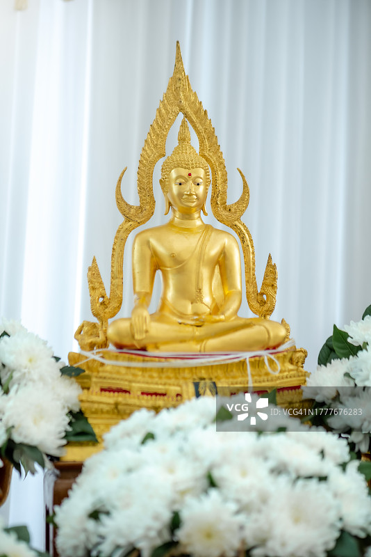 佛陀优雅地在桔黄色背景的莲花上打坐。(佛教)图片素材
