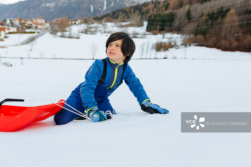 男孩在雪地上玩单板滑雪图片素材