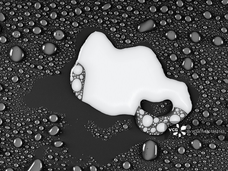 大滴液态奶与小滴水混合在灰色潮湿的表面上。图片素材
