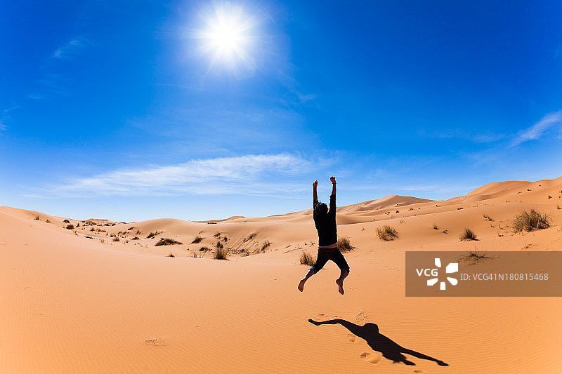 自由，快乐的人在撒哈拉沙漠跳跃图片素材